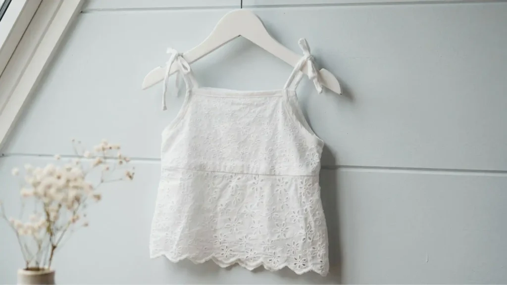 Eyelet crochet summer tank top for kids in white cotton yarn with ribbon tie straps — free pattern