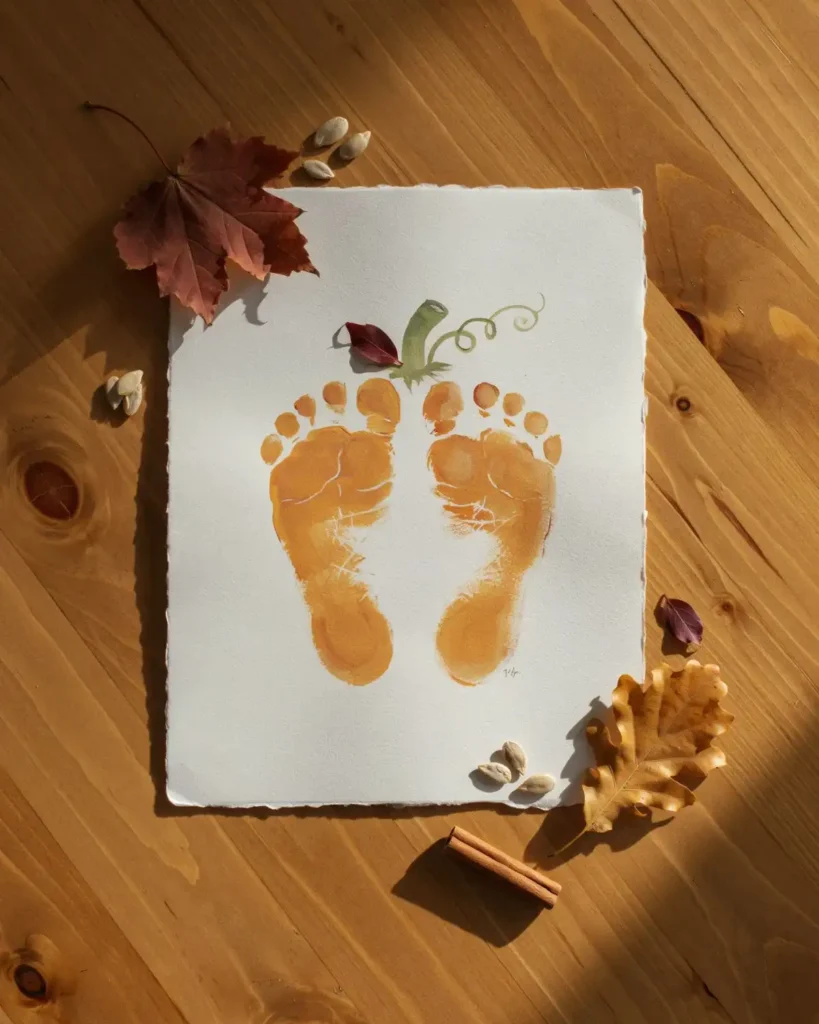 Pumpkin footprint art fall baby craft made from a tiny orange footprint