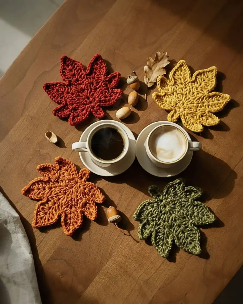 Crochet maple leaf coasters in red, mustard, orange and green
