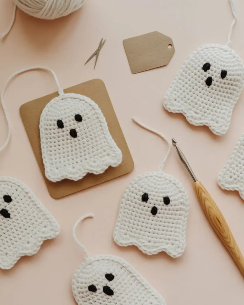 Flat white crochet ghost appliqués used on a card and gift tag.