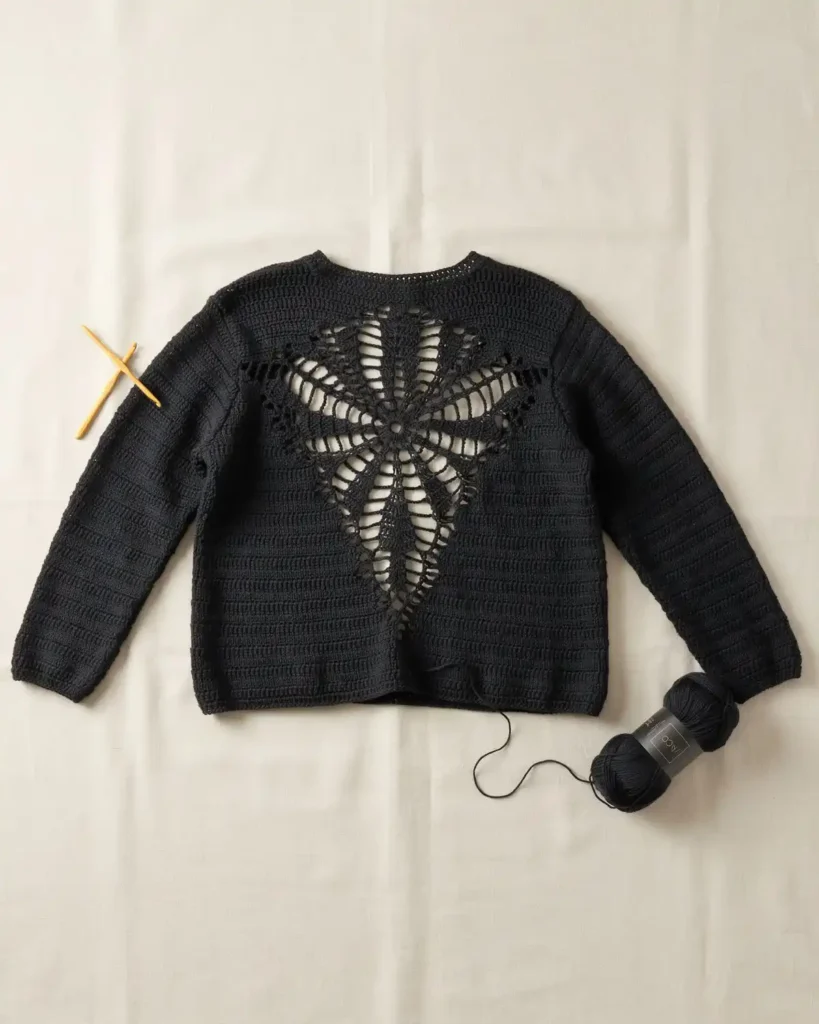 Black crochet spider web sweater with a large openwork web back panel.