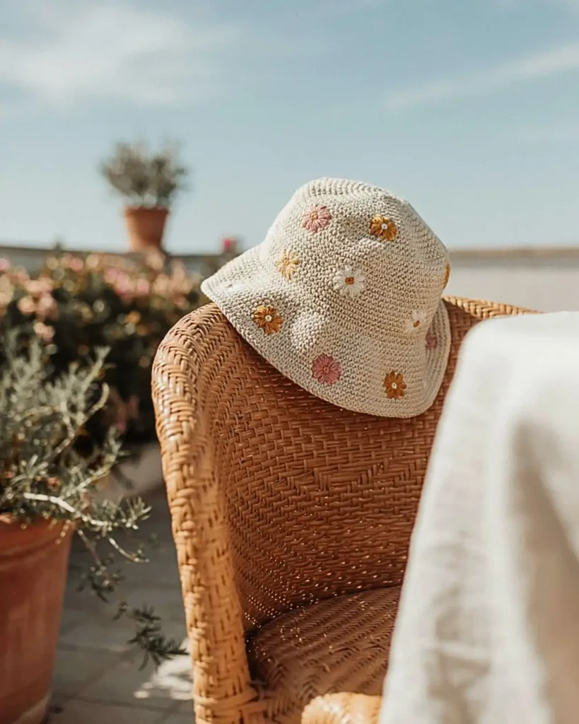 Cream crochet bucket hat decorated with colorful daisy motifs
