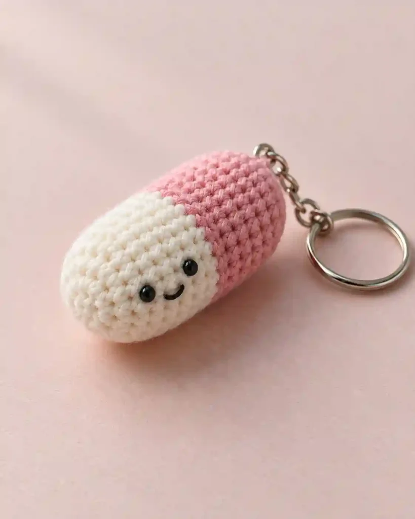 Landscape editorial photo of a clearly plush pastel-blue and white crochet syringe toy with softly rounded end; crochet syringe plush, realistic visible crochet stitch detail.