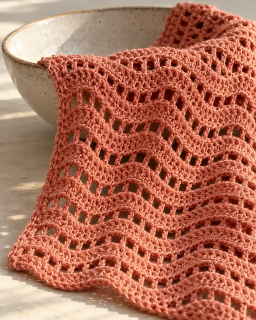 Coral wavy crochet mesh stitch showing smooth undulating openings