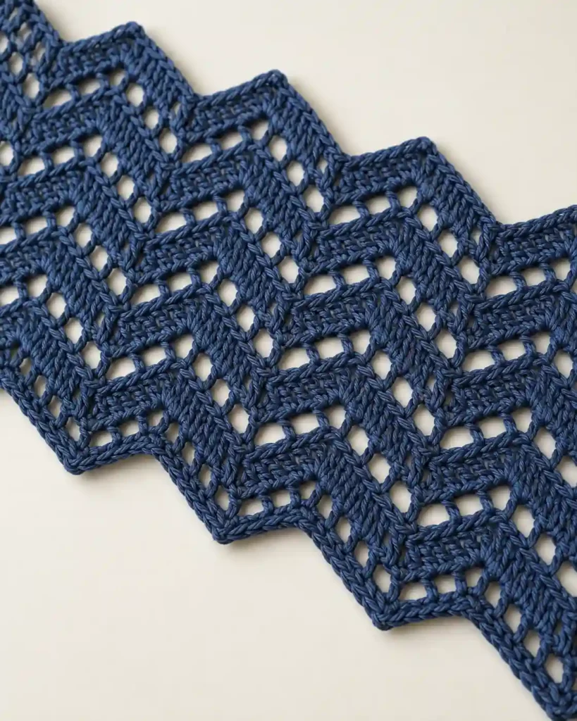 Indigo zigzag crochet mesh swatch with angular chevron lace design